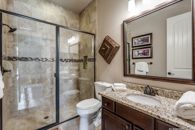 bathroom with toilet, a shower with shower door, and vanity