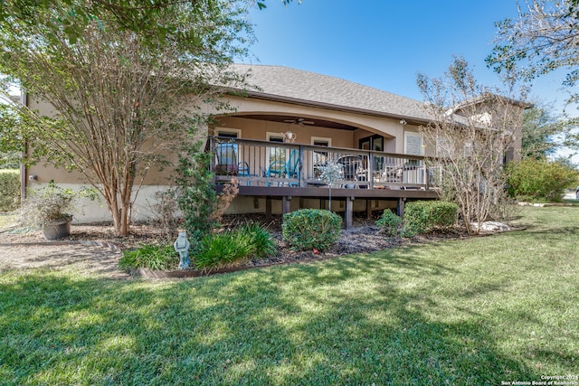 rear view of house featuring a yard, a deck, and ceiling fan