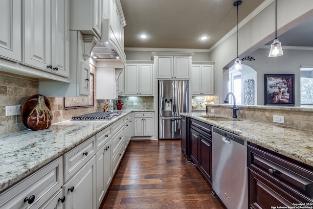 kitchen with white cabinets, tasteful backsplash, appliances with stainless steel finishes, pendant lighting, and sink