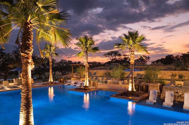 pool at dusk with a patio area