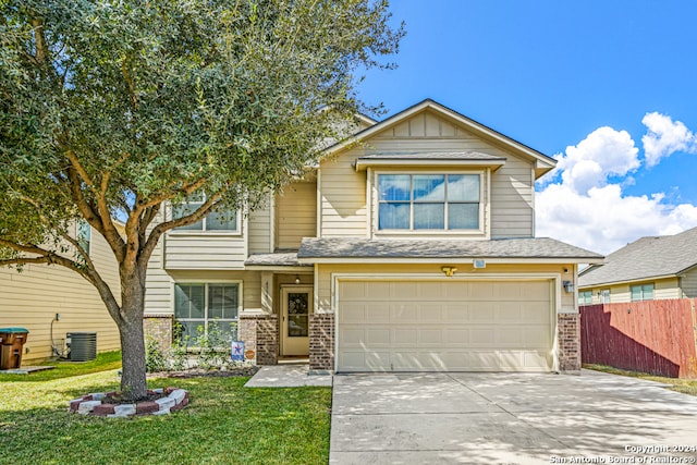 view of front of home with a front lawn, central AC unit, and a garage