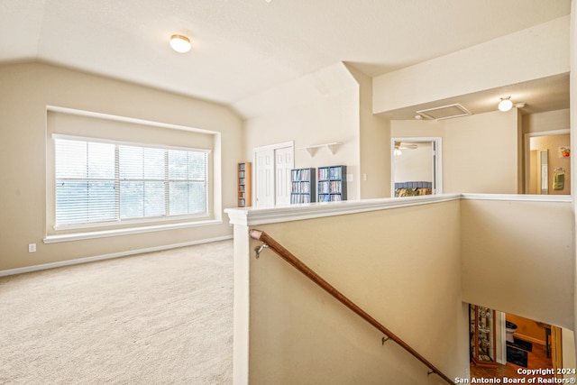 hallway with lofted ceiling and carpet flooring