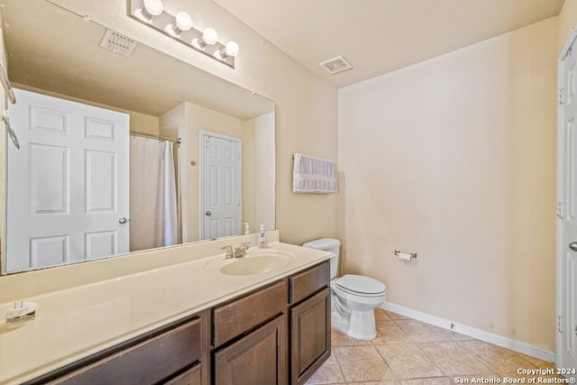 bathroom featuring vanity, toilet, and tile patterned flooring