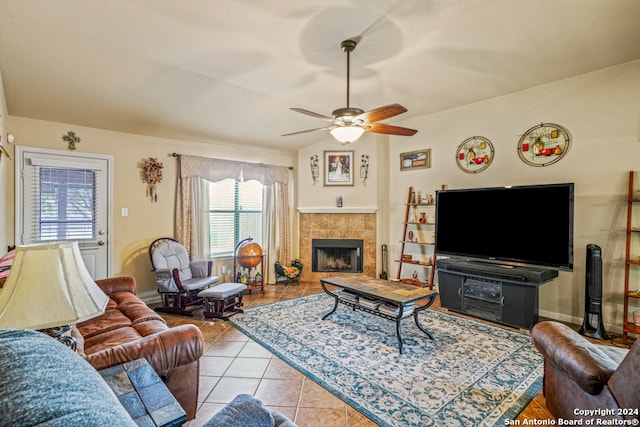 tiled living room with a tile fireplace and ceiling fan