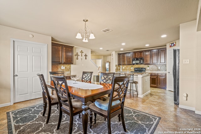 dining area featuring a notable chandelier and a textured ceiling