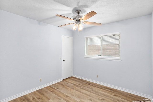 spare room with a textured ceiling, light hardwood / wood-style floors, and ceiling fan