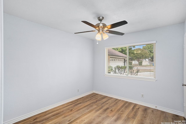 spare room featuring wood-type flooring and ceiling fan