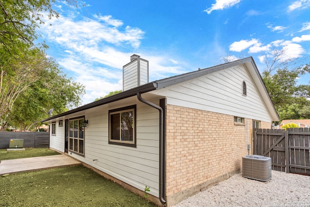 view of side of property featuring a patio and central AC