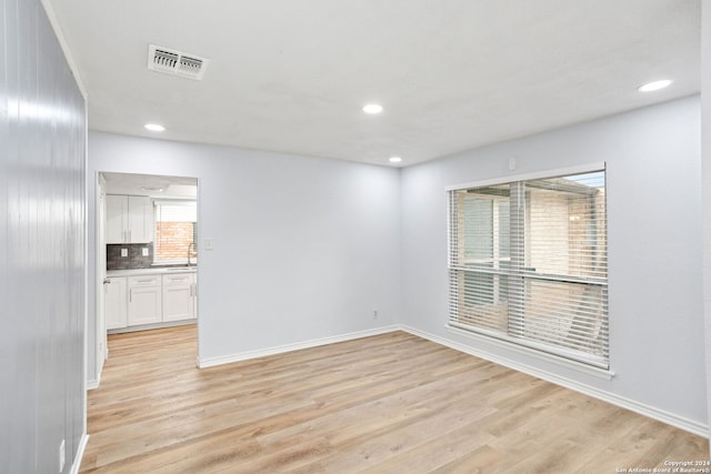 spare room with light hardwood / wood-style floors and sink