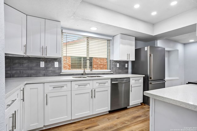 kitchen featuring light hardwood / wood-style floors, white cabinets, stainless steel appliances, and sink