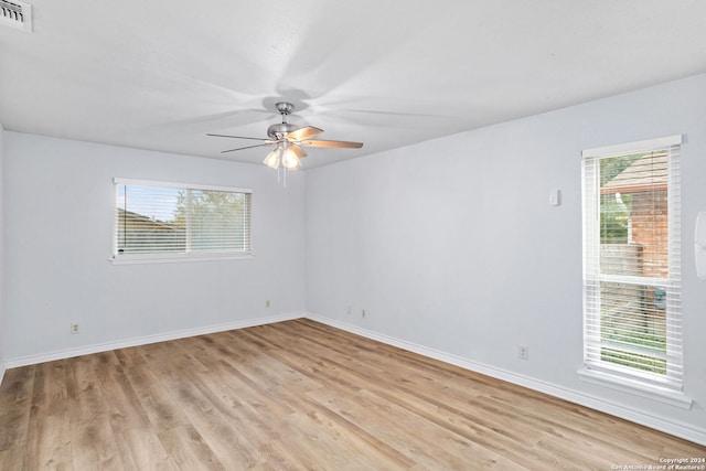 unfurnished room featuring ceiling fan, light wood-type flooring, and a wealth of natural light