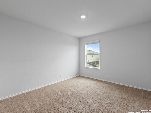 spare room with baseboards and carpet flooring