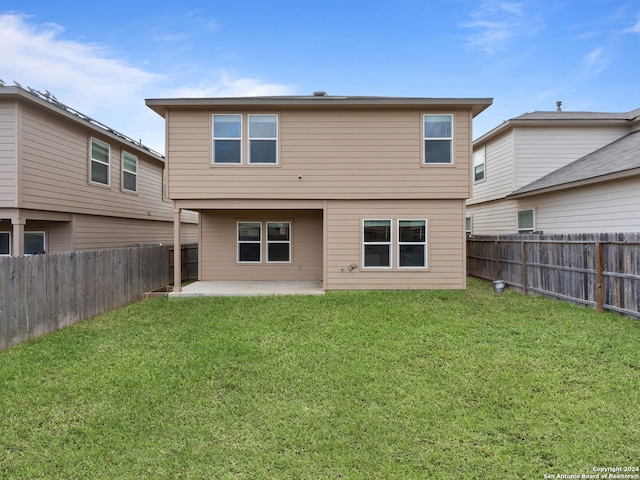 rear view of house featuring a patio area and a yard