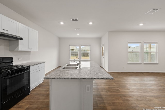 kitchen with gas stove, white cabinetry, and an island with sink