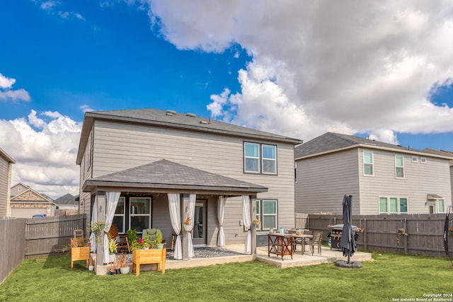 rear view of house with a patio area and a lawn