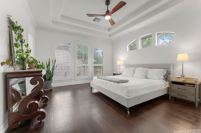 bedroom with ceiling fan, crown molding, dark hardwood / wood-style flooring, and a tray ceiling