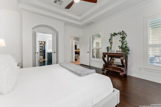 bedroom with a tray ceiling, crown molding, ceiling fan, and dark hardwood / wood-style floors