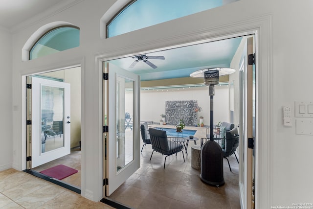 doorway featuring french doors, ceiling fan, crown molding, and light tile patterned floors