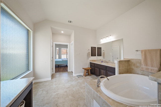 bathroom with vanity, tiled tub, and tile patterned floors