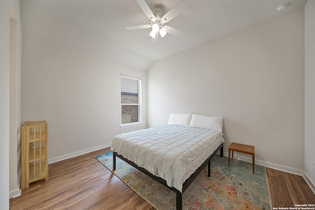 bedroom with hardwood / wood-style flooring, vaulted ceiling, and ceiling fan