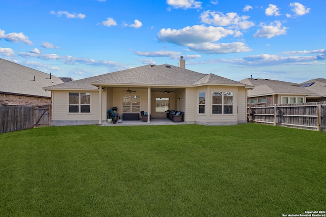 back of property with a yard, a patio area, and ceiling fan