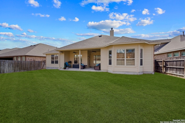 rear view of house with a yard, ceiling fan, and a patio