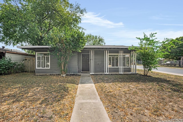 view of front facade featuring a front lawn and a sunroom