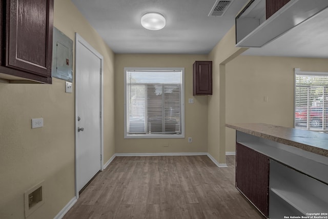 interior space featuring electric panel and light hardwood / wood-style flooring