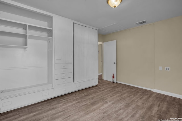 unfurnished bedroom featuring multiple closets and light hardwood / wood-style flooring