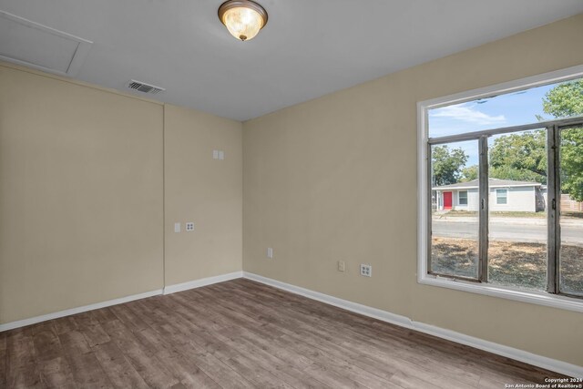 empty room with hardwood / wood-style floors and plenty of natural light