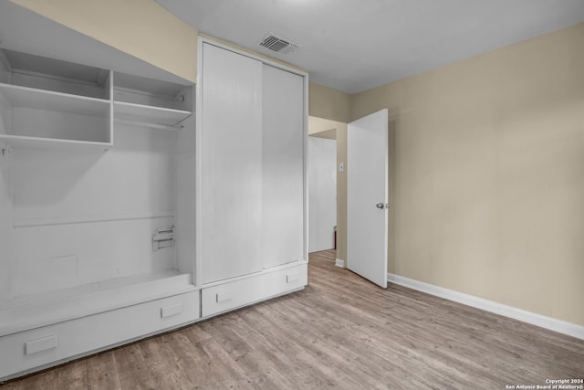 unfurnished bedroom featuring a closet and light wood-type flooring