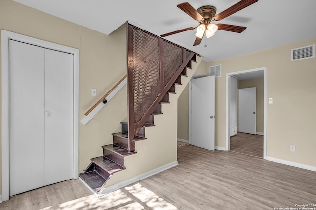 staircase featuring hardwood / wood-style floors and ceiling fan