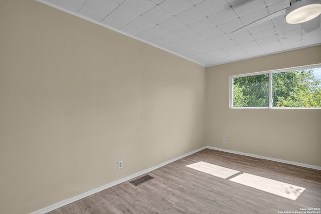 empty room featuring ornamental molding and hardwood / wood-style flooring