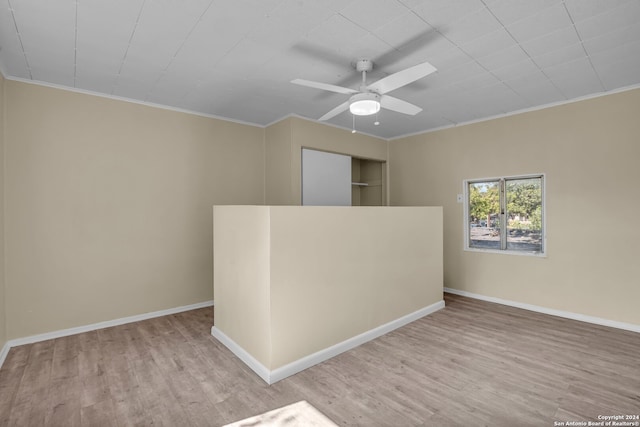 spare room featuring crown molding, ceiling fan, and light wood-type flooring