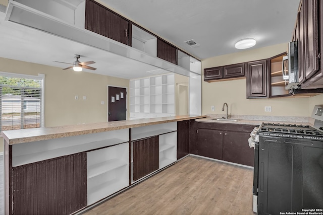 kitchen featuring light hardwood / wood-style flooring, kitchen peninsula, dark brown cabinets, sink, and appliances with stainless steel finishes