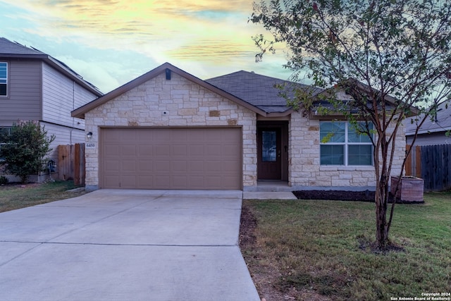 view of front of property with a garage and a lawn