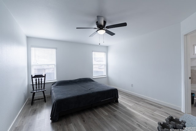 bedroom with hardwood / wood-style floors, multiple windows, and ceiling fan