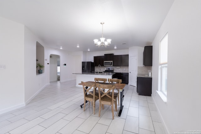 dining space featuring sink, a notable chandelier, and light tile patterned floors