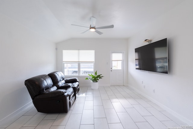 living room featuring lofted ceiling, light tile patterned flooring, and ceiling fan