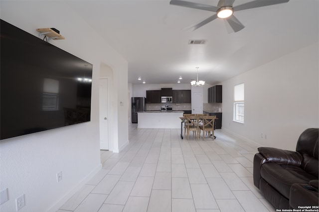 tiled living room featuring ceiling fan with notable chandelier