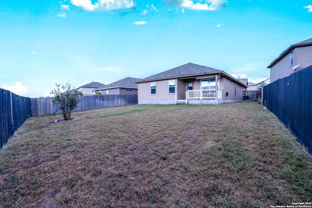 rear view of property featuring a yard