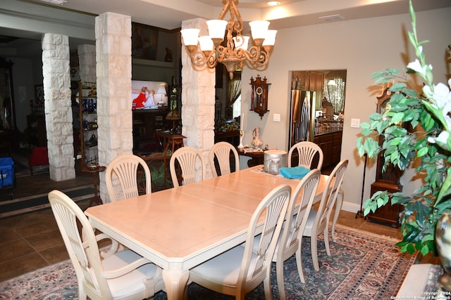 dining area featuring tile patterned floors, decorative columns, and a chandelier