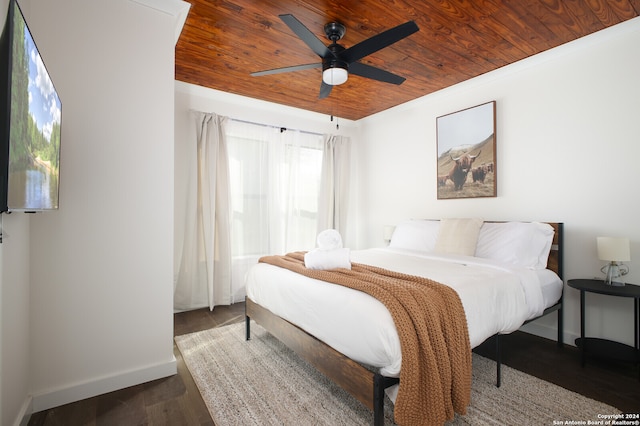 bedroom with dark hardwood / wood-style flooring, ornamental molding, wooden ceiling, and ceiling fan