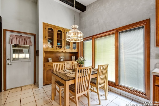 dining area with a notable chandelier, beam ceiling, high vaulted ceiling, and light tile patterned floors