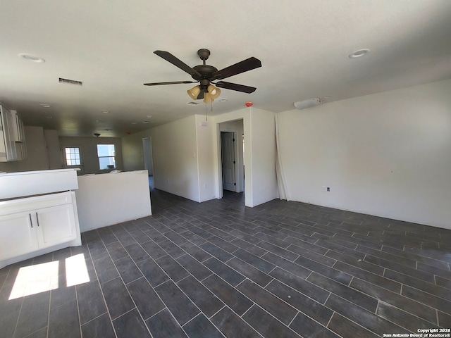 unfurnished living room featuring dark hardwood / wood-style floors and ceiling fan