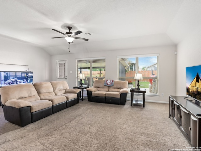 carpeted living room with ceiling fan and vaulted ceiling