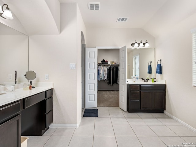 bathroom featuring vanity, vaulted ceiling, and tile patterned flooring