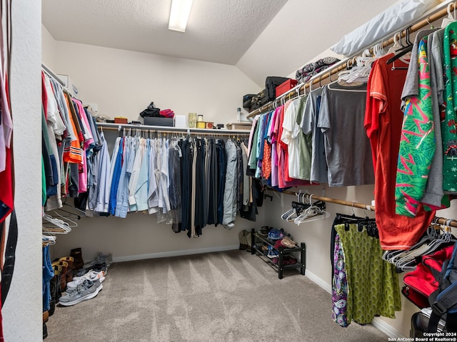 walk in closet with carpet and vaulted ceiling