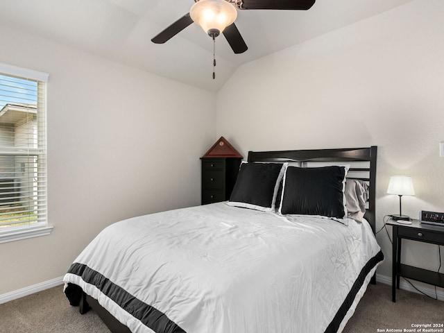 carpeted bedroom featuring ceiling fan, vaulted ceiling, and multiple windows