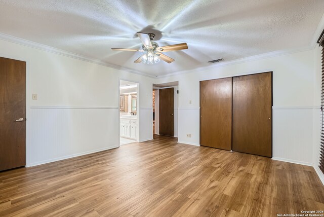 unfurnished bedroom with light hardwood / wood-style floors, crown molding, a textured ceiling, and ceiling fan